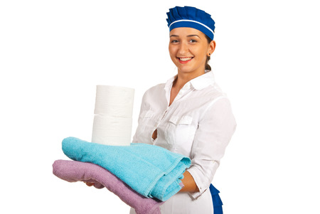 Happy maid holding clean towels and rolls of toilet paper isolated on white backgroundの写真素材