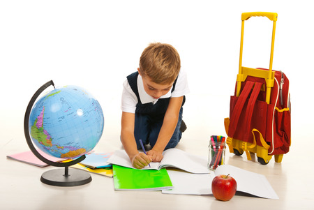 Boy making homework and sitting on floor in livingroomの写真素材