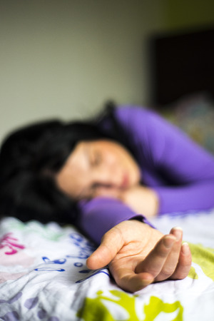 Sleeping woman in her bed,selective focus on her handの写真素材