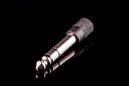 Silver plated 3.5 mm audio jack against black background