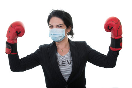 Victorious business woman with boxing gloves and protective mask  against coronavirus disease isolated on white backgroundの写真素材