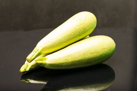Fresh green zucchini against black background with reflectionの写真素材