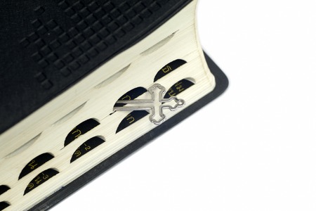 Closeup of Christian crucifix necklace next to holy Bibleの写真素材