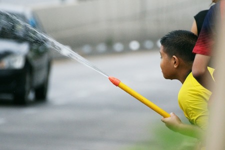 CHIANGMAITHAILANDAPRIL 142011: The boy with water pressure gun in a water fight festival or Songkran Festival Thai New Year on April 14 2011 in Chiangmai Thailand.のeditorial素材