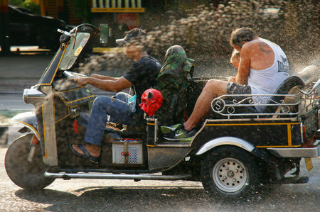 CHIANGMAITHAILANDAPRIL 14 2011:Unidentified tourist with traditional tuktuk in a water fight...