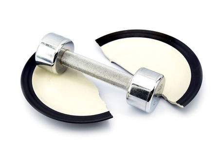 Dumbbell on a broken plate. The concept of a healthy lifestyle diet sports weight loss exercise.の写真素材