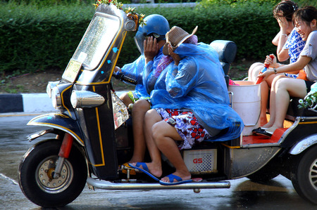 CHIANGMAI,THAILAND-APRIL 14, 2011:Unidentified tourist with traditional tuk-tuk in a water fight festival or Songkran Festival Thai New Year, on April 14, 2011 in Chiangmai, Thailand.のeditorial素材