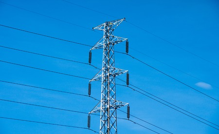 High voltage post or power transmission line tower and blue skyの写真素材