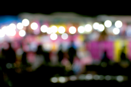 Defocused and blurred image of people at amusement park at night for background usage.の写真素材