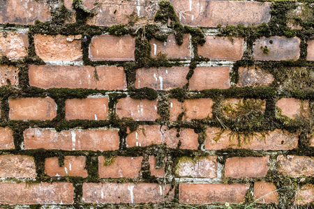 broken brick wall background in sunny summer day. Abstract red brick old wall texture background. Ruins uneven crumbling red brick wall background texture.の写真素材