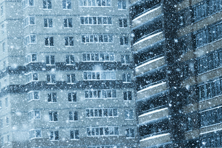 heavy snowfall in the city against the background of residential buildings in one of the districtsの写真素材