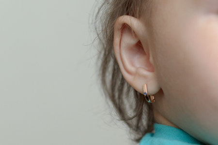 the child with the pierced ears is younger than three years