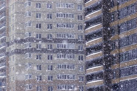 Heavy snowfall, snow against the background of residential districtsの写真素材