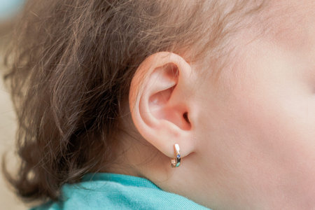 the child with the pierced ears is younger than three years
