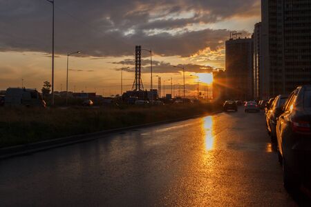 St. Petersburg, Russia June 2019-Murino district, sunset after rain on asphalt traces of water and reflection of light in waterのeditorial素材