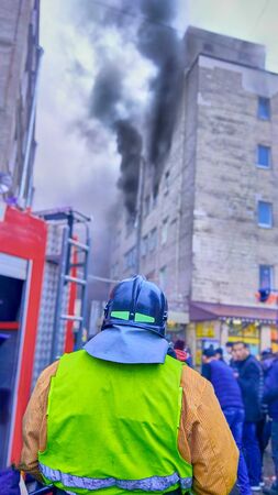 firefighter in front of a fire in a high-rise trade building, fighting fires in a big cityの写真素材
