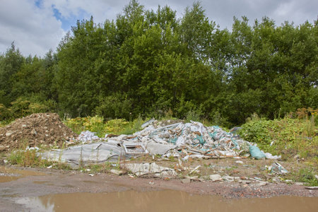illegally dumped garbage on the background of green nature.