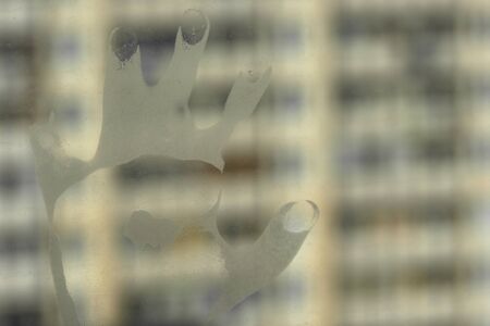 silhouette of the hand on the window symbolizing the concept of anxietyの写真素材