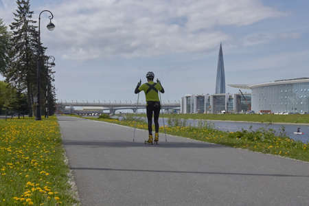 Russia, Saint-Petersburg, 10 July 2019: Cross-country skiing in summer among the grass and against the background of the city.のeditorial素材