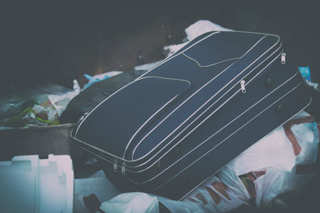 travel suitcase for air travel in the trash in the trash among the garbage.