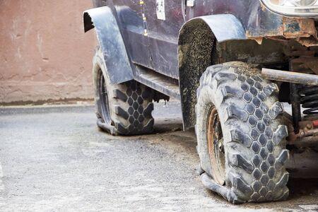 SUV with a flat wheel in the city Parking lotの写真素材