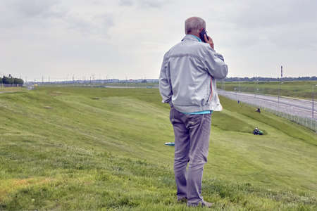 Russia, Saint-Petersburg, July 2019: the customer controls how the lawn mower tractor works on a large area with lawn.のeditorial素材