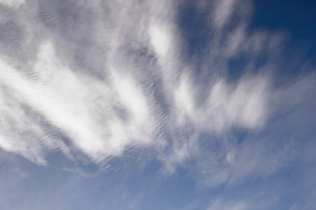 Cirrus clouds against a blue sky view from below.