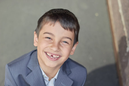 back to school portrait of a young boy with a backpack and a business suit.