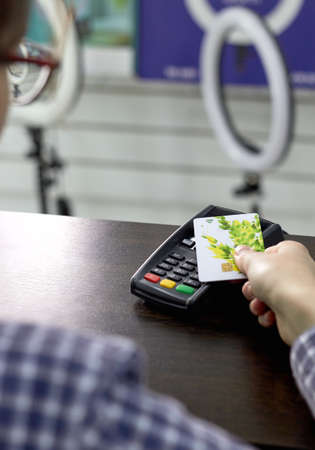 young girl pays for a purchase with a cardの写真素材