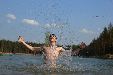 cute boy happily bathes in the water.の写真素材