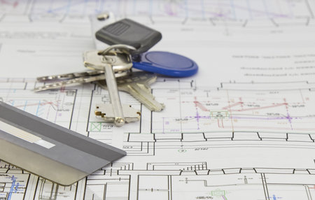architectural plan of the house on the sheet are the keys and credit card, the concept of buying a...