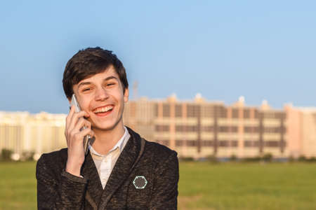 Teen talks on mobile phone amid urban landscapeの写真素材