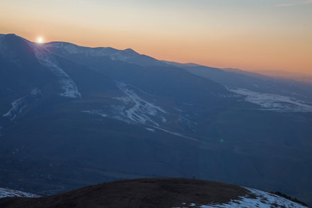 Beautiful landscape in the mountains at sunset. View of the misty hills hidden behind the oncoming...