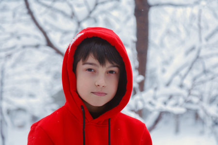 Child in a winter forest in a bright red sweaterの写真素材