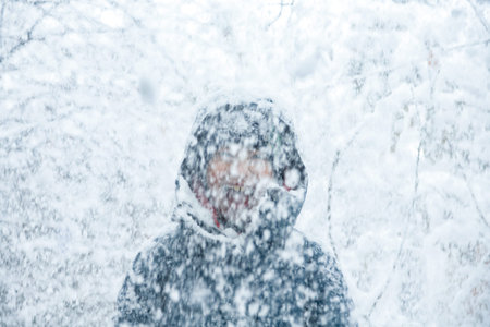 Outdoor winter portrait of little healthy happy baby child walking in the park on cold day with snow...