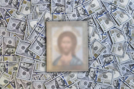 silhouette of a religious icon against a background of hundred-dollar billsの写真素材