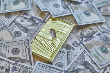 silhouette of a religious icon against a background of hundred-dollar billsの写真素材