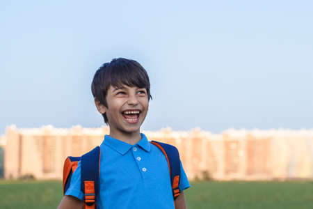 Portrait of happy boy with backpack, school child waiting for school bus, primary school student, on the way to schoolの写真素材