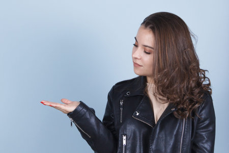 the brunette lady in the dark jacket makes a hand gesture on her palm.