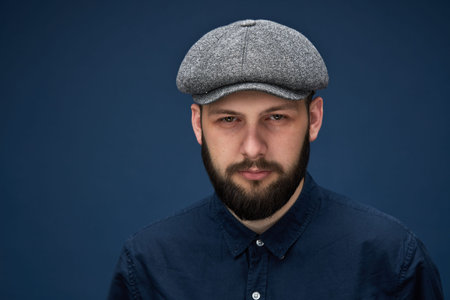 Portrait of retro bearded guy in a coat on a dark smoky background