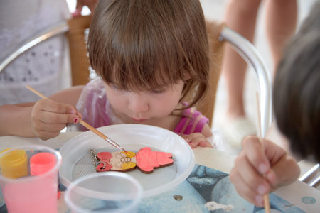 The child draws with a brush, a manifestation of creativity in the baby.の写真素材