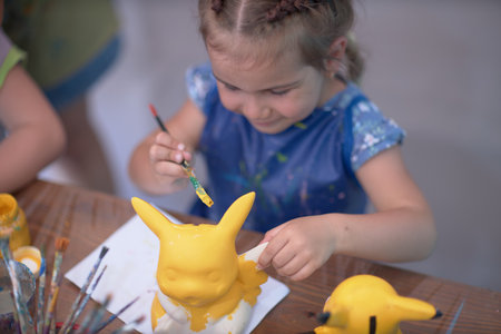 Girls 4-5 years old are sitting at a table and painting with colorful paints. Childrens creativity. Childrens hobbies.の写真素材