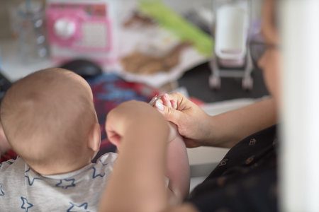 mommy cuts her nails for a childの写真素材