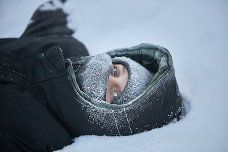 Person Laying in Snow With Hood Onの写真素材