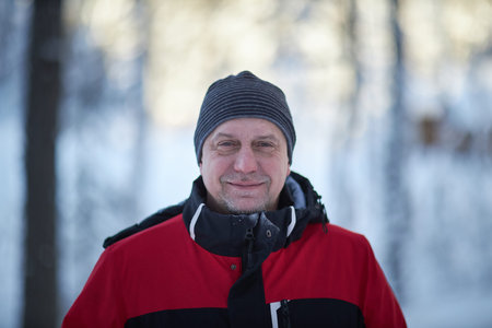 Man 50 years old Wearing Red and Black Jacket in Snowの写真素材