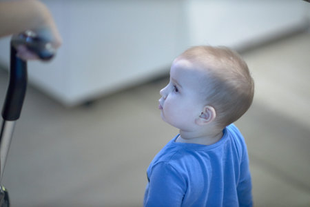 Child Looks Up at Person With Remote Control