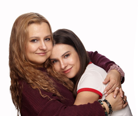 Embracing Unity: Two Women Share a Moment of Pure Connection Against a White Backdropの写真素材