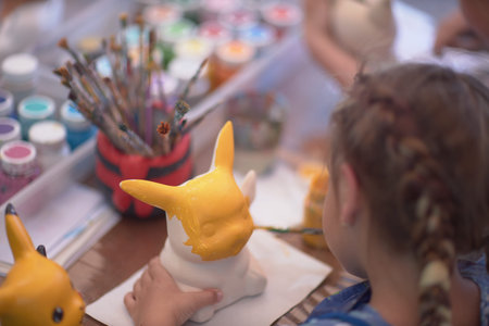 Girls 4-5 years old are sitting at a table and painting with colorful paints. Childrens creativity. Childrens hobbies.の写真素材