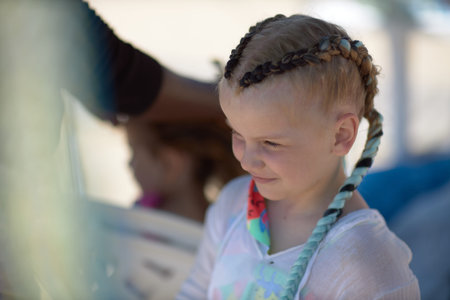 stylist braiding hair on a young child.