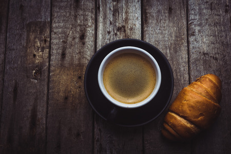 Croissant and coffee cup on a wooden backgroundの写真素材